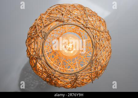 Lampadario moderno con paralume di paglia a forma di sfera, vista dal basso, foto ravvicinata Foto Stock