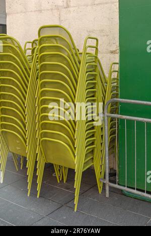 Sedie in metallo verde impilate di fronte al ristorante Francia Foto Stock