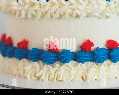 torta di ghiaccio ghiacciata bianca blu rossa isolata su sfondo bianco studio. Colori della bandiera americana. Celebrazione. Foto Stock