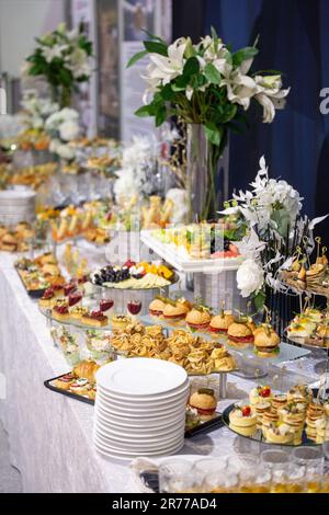 vari snack e bevande al tavolo a buffet durante l'evento di catering aziendale. Foto Stock