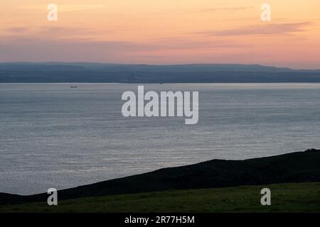 La luce dell'alba cade sulla costa e sulle colline del Galles del Sud, tra cui i punti di riferimento della centrale elettrica di Aberthaw, Garth Hill e il trasmettitore di Wenvoe, come si vede da avanti Foto Stock