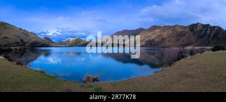 Fotografia del Lago Mike con le montagne che si riflettono nell'acqua in una giornata nuvolosa al di fuori di Queenstown, sull'Isola Sud della Nuova Zelanda Foto Stock