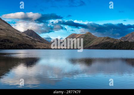 Fotografia del Lago Mike con le montagne che si riflettono nell'acqua in una giornata nuvolosa al di fuori di Queenstown, sull'Isola Sud della Nuova Zelanda Foto Stock