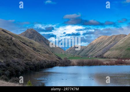 Fotografia del Lago Mike con le montagne che si riflettono nell'acqua in una giornata nuvolosa al di fuori di Queenstown, sull'Isola Sud della Nuova Zelanda Foto Stock