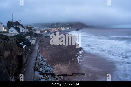 Il lungomare Esplanade è illuminato al crepuscolo nella città balneare di Sidmouth, sulla Jurassic Coast del Devon. Foto Stock