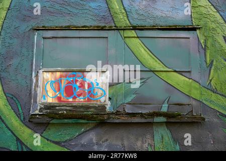 Closeup delle pareti colorate di un vecchio edificio e graffiti urbani a Mount Pleasant, Vancouver, BC, Canada Foto Stock