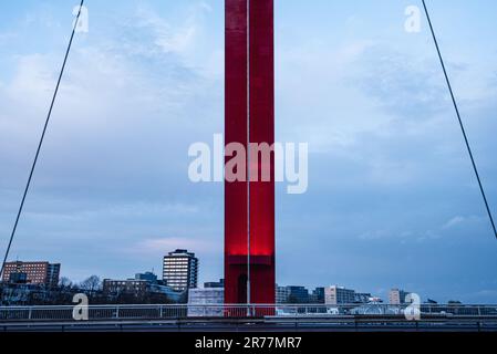 Pilastro di un ponte sospeso rosso contro un cielo blu e skyline Foto Stock