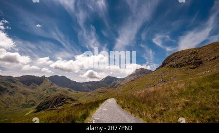 Un escursionista si avvicina alla montagna di Snowdon sulla pista dei minatori nel Galles del Nord. Foto Stock