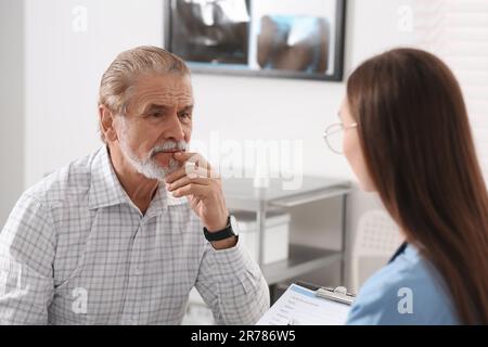 Paziente professionale di consulenza ortopedica femminile in clinica Foto Stock