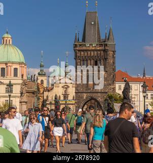 PRAGA, REPUBBLICA CECA - turisti che attraversano il Ponte Carlo. Torre del Ponte della Città Vecchia sul retro. Foto Stock