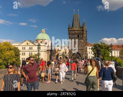 PRAGA, REPUBBLICA CECA - turisti che attraversano il Ponte Carlo. Torre del Ponte della Città Vecchia sul retro. Foto Stock