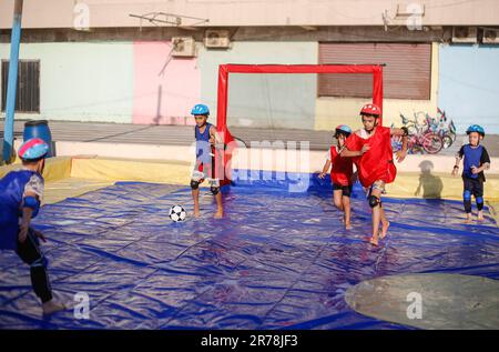 Gaza, Palestina. 12th giugno, 2023. I bambini palestinesi giocano a calcio nella prima città dei giochi d'acqua. Uomini d'affari palestinesi fondarono la prima città di giochi d'acqua nella striscia di Gaza. I palestinesi hanno sofferto per la mancanza di luoghi di svago a causa del blocco israeliano e delle complesse condizioni economiche e politiche subite dai residenti della striscia di Gaza. (Foto di Ahmed Zakot/SOPA Images/Sipa USA) Credit: Sipa USA/Alamy Live News Foto Stock