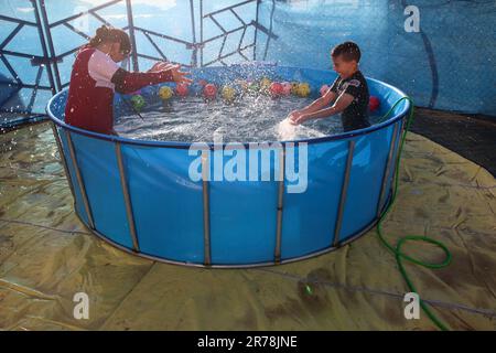 Gaza, Palestina. 12th giugno, 2023. I bambini palestinesi giocano nella prima città dei giochi d'acqua. Uomini d'affari palestinesi fondarono la prima città di giochi d'acqua nella striscia di Gaza. I palestinesi hanno sofferto per la mancanza di luoghi di svago a causa del blocco israeliano e delle complesse condizioni economiche e politiche subite dai residenti della striscia di Gaza. (Foto di Ahmed Zakot/SOPA Images/Sipa USA) Credit: Sipa USA/Alamy Live News Foto Stock