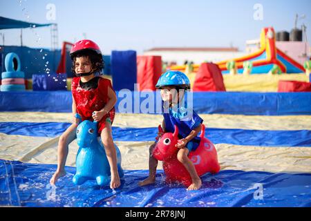 Gaza, Palestina. 12th giugno, 2023. I bambini palestinesi giocano nella prima città dei giochi d'acqua. Uomini d'affari palestinesi fondarono la prima città di giochi d'acqua nella striscia di Gaza. I palestinesi hanno sofferto per la mancanza di luoghi di svago a causa del blocco israeliano e delle complesse condizioni economiche e politiche subite dai residenti della striscia di Gaza. (Foto di Ahmed Zakot/SOPA Images/Sipa USA) Credit: Sipa USA/Alamy Live News Foto Stock