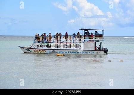 Barche con fondo in vetro a Pigeon Point che trasportano turisti in tour per vedere la barriera corallina di Buccoo, la piscina di Nylon e la Terra di No Man a Tobago. Foto Stock