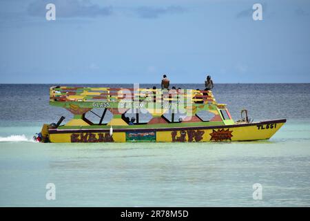 Barche con fondo in vetro a Pigeon Point che trasportano turisti in tour per vedere la barriera corallina di Buccoo, la piscina di Nylon e la Terra di No Man a Tobago. Foto Stock