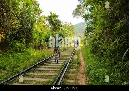 Gli abitanti del posto attraversano la linea ferroviaria principale di Ella, Sri Lanka. La linea inizia nel forte di Colombo e si snoda attraverso il paese collinare dello Sri Lanka fino a raggiungere Foto Stock