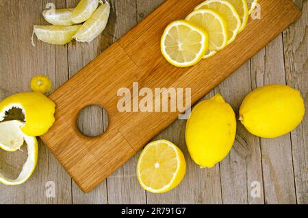 Immagine ravvicinata di limoni freschi a fette su un asse di legno Foto Stock