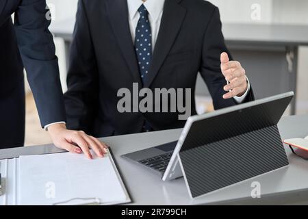 Uomo d'affari asiatico che guida il suo subordinato nel suo lavoro Foto Stock