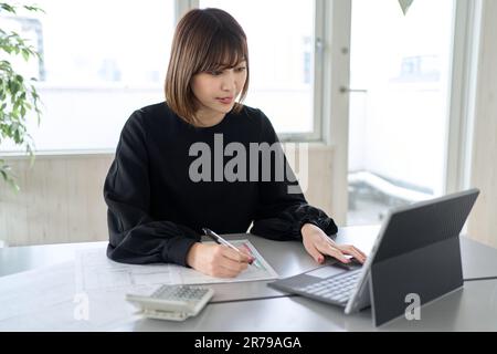 Donna asiatica che prepara documenti di dichiarazione dei redditi Foto Stock