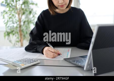 Donna asiatica che prepara documenti di dichiarazione dei redditi Foto Stock