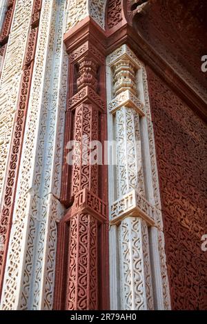 Motivi decorativi della parete del complesso Qutb a Delhi del sud, India, primo piano antiche decorazioni a bassorilievo della parete delle rovine della moschea punto di riferimento, popolare turista Foto Stock