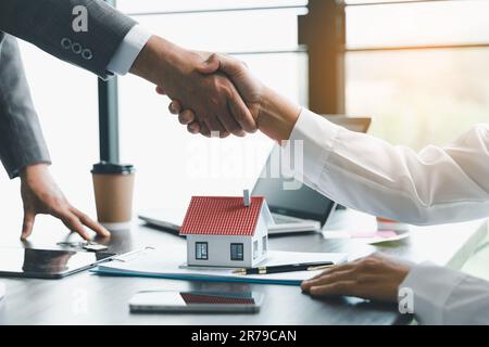 Successo di affari, agenti immobiliari e clienti scuotono le mani per congratularsi dopo la firma di un contratto per acquistare una casa con la terra e l'assicurazione, handsh Foto Stock