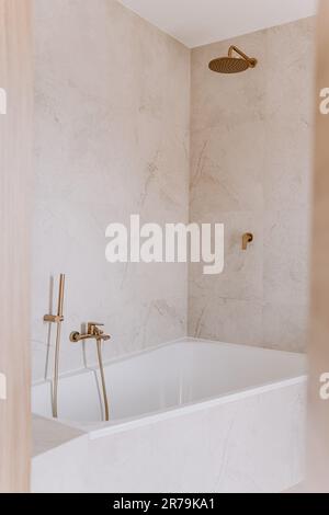 Un'immagine interna di un bagno moderno con una grande vasca nel centro Foto Stock