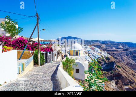Una strada acciottolata in cima alla scogliera a Fira, capitale dell'isola di Santorini. Si tratta di una tipica architettura delle Cicladi con incredibili case bianche tradizionali Foto Stock