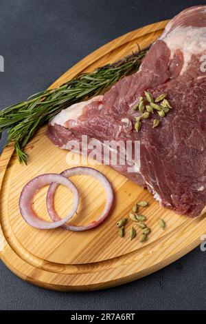 Un grosso pezzo di carne cruda su fondo nero Foto Stock