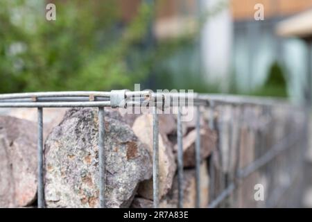 Primo piano di un filo di rete di gabion riempito di pietre Foto Stock