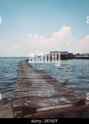 Un molo di legno intatto che si aggetta in un lago, con le tavole di legno strappate via per permettere ad una barca di passare attraverso Foto Stock