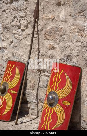 vista verticale di due scudi di colore rosso e lancia di un soldato proveniente da legioni dell'antica roma Foto Stock