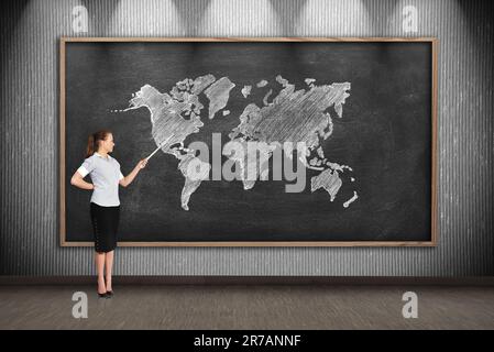 insegnante con puntatore per disegnare la mappa del mondo sulla lavagna Foto Stock
