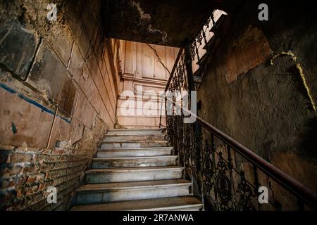 Vecchie scale in vecchia casa abbandonata a Tbilisi. Foto Stock