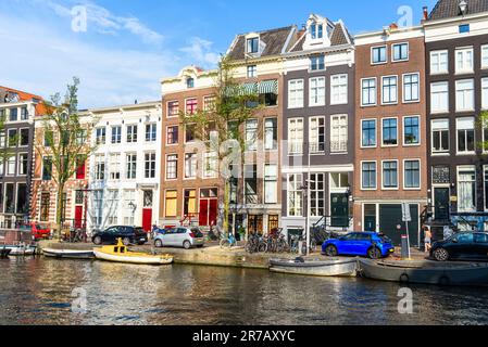 Tradizionali case olandesi lungo un canale di Amsterdam in una giornata di sole Foto Stock