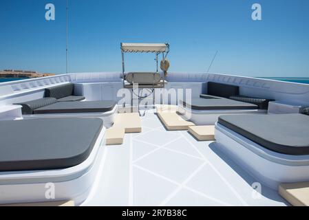 Terrazza solarium di un grande yacht a motore di lusso con lettini e sfondo tropicale con vista mare Foto Stock