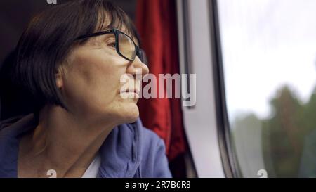 Varsavia, Polonia. 11th giugno, 2023. Anziana signora in occhiali viaggia in treno e guarda fuori dalla finestra (Credit Image: © Andrey Nekrasov/ZUMA Press Wire) SOLO PER USO EDITORIALE! Non per USO commerciale! Foto Stock
