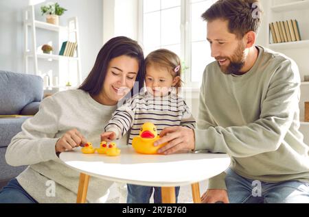 Papà, mamma e bimbo bambino che gioca a giocattoli a casa Foto Stock