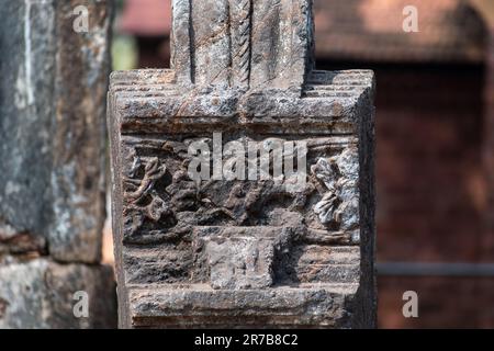Particolare di una vecchia era portoghese sbiadita intagliata su una colonna di pietra presso il sito patrimonio dell'umanità dell'UNESCO di Old Goa. Foto Stock