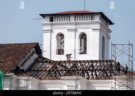 Old Goa, India - Gennaio 2023: Lavoratori che fissano il tetto piastrellato dell'antica chiesa portoghese di San Francesco d'Assisi nella Vecchia Goa. Foto Stock