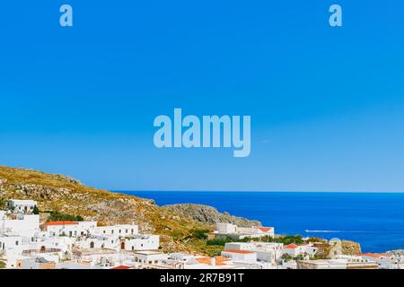 Vista della città di Lindos e del mare smeraldo sull'isola di Rodi, le isole greche dell'arcipelago dodecanese, Europa. Vacanze e popolare Foto Stock