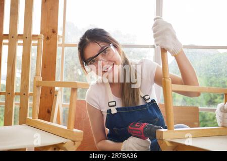 Ritratto dell'operatrice carpentiera femminile con un cacciavite elettrico Foto Stock