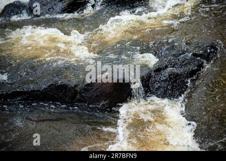 Un tranquillo ruscello d'acqua si snoda attraverso un paesaggio roccioso Foto Stock