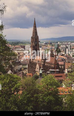 Una torre dell'orologio si erge alta contro lo skyline della città, con la sua guglia che raggiunge il cielo Foto Stock