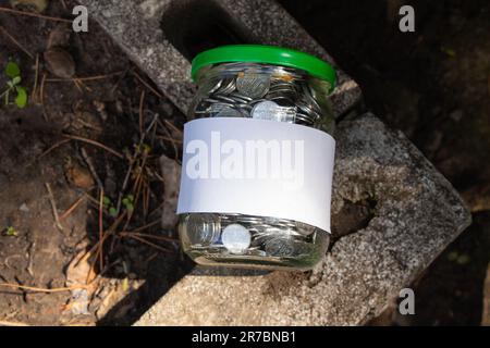 Barattolo con monete ucraine e un'etichetta bianca con posto per i supporti di testo Foto Stock