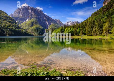 immagine sul lago delle montagne innevate delle alpi giulie riflessa nelle acque calme del lago predil in italia Foto Stock