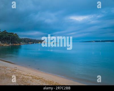 Sfumature di blu tramonto e crepuscolo a legges Beach, Twofold Bay a Eden sulla costa meridionale del New South Wales, Australia. Foto Stock