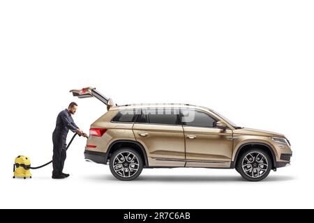 Lavoratore che pulisce un SUV con un aspirapolvere isolato su sfondo bianco Foto Stock