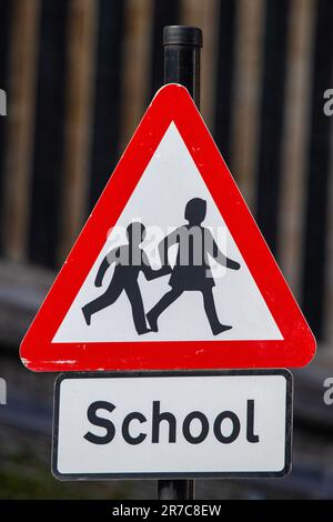 Primo piano di un cartello stradale School and Children Crossing nel Regno Unito. Foto Stock